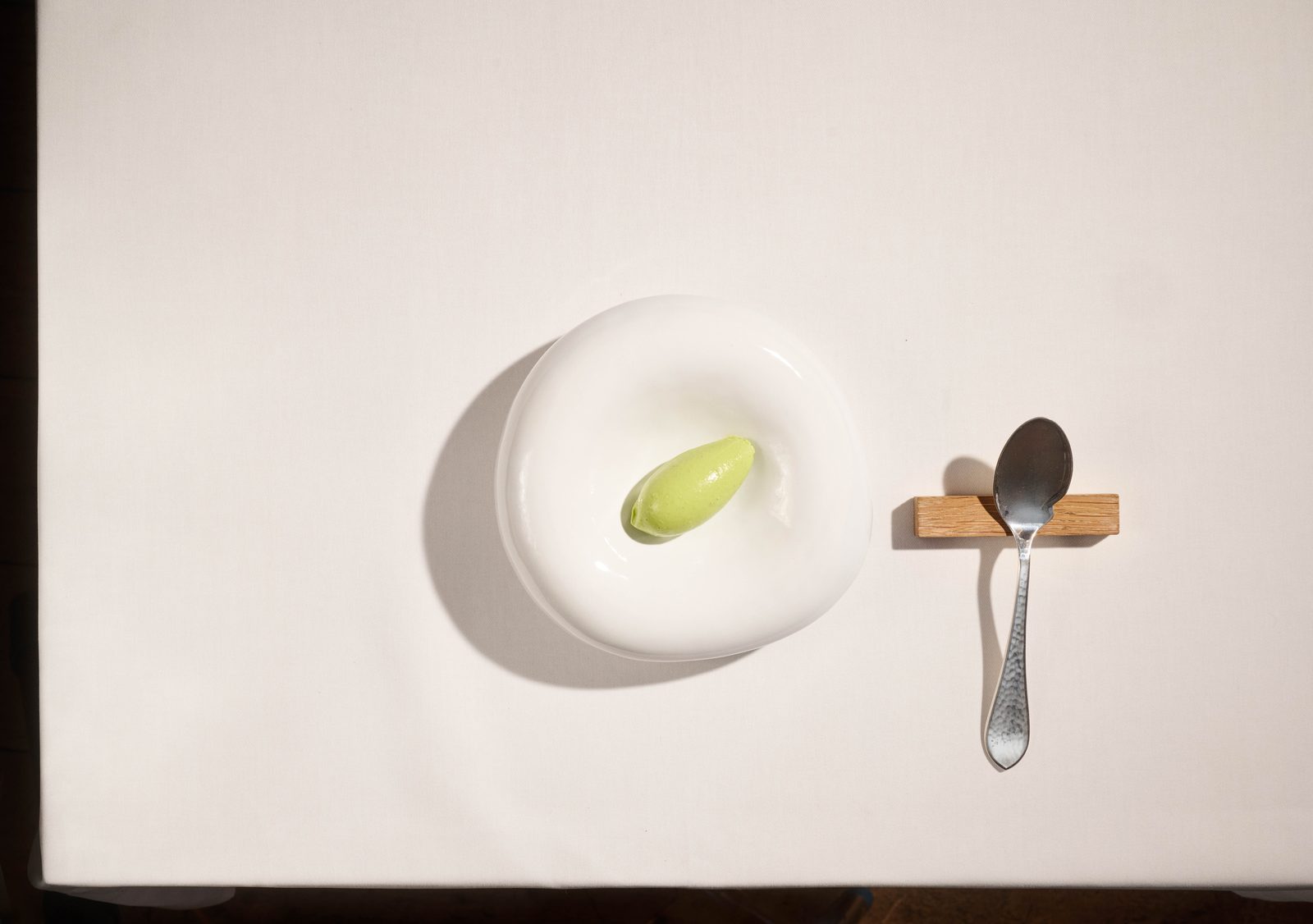 Grüne-Sauce-Eis-Quenelle am gedeckten Tisch